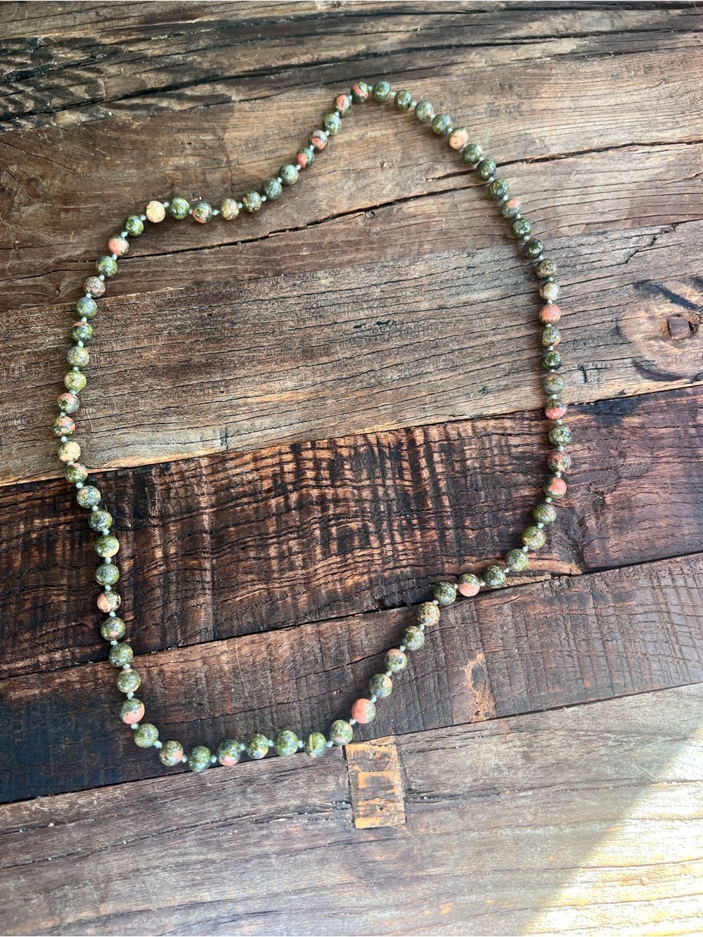unakite gemstone necklace features mottled green and pink beads